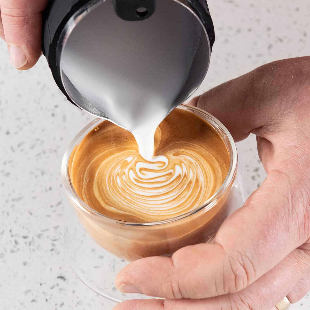 Pouring latte art from the Flair Milk Pitcher that was steamed on the Flair eWizard.