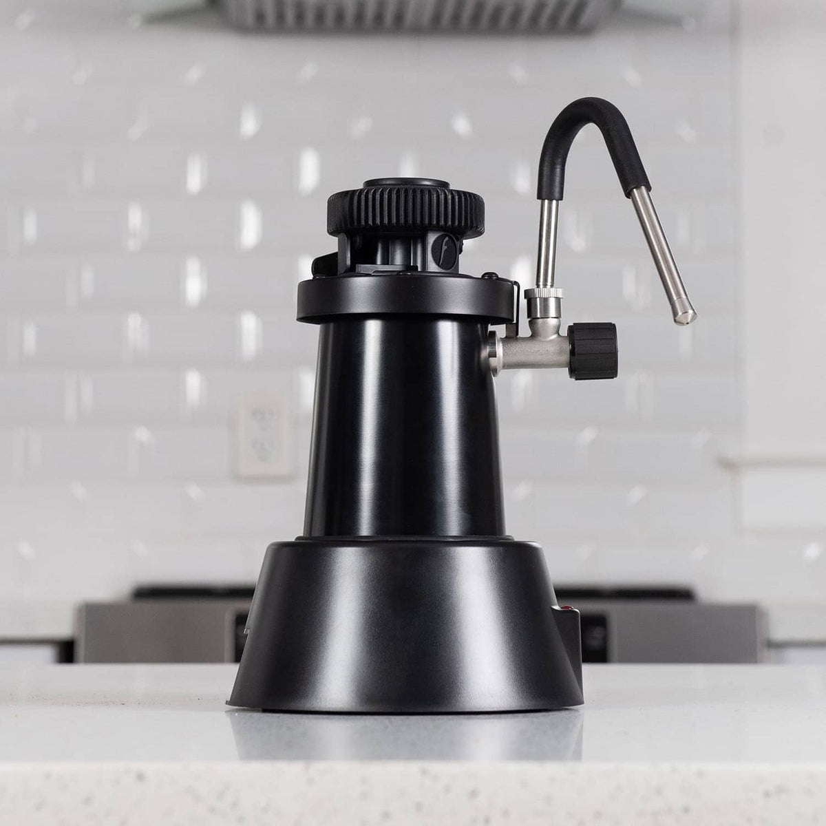 Flair eWizard electric milk steamer on a counter in a white kitchen.