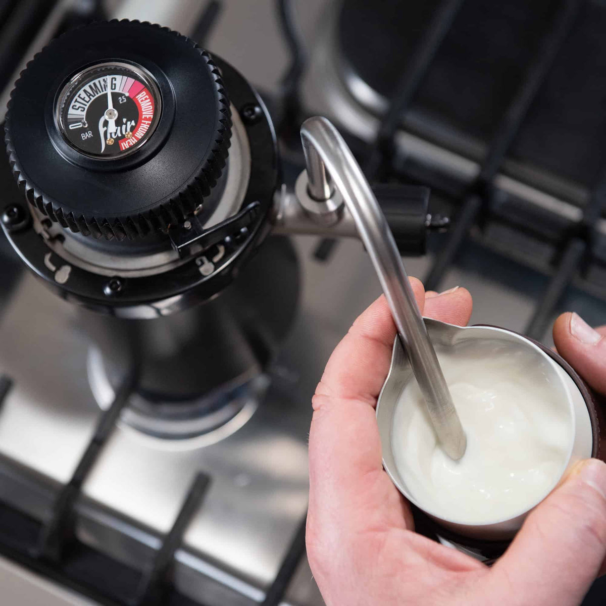 Top down view of the Flair Wizard Stovetop Milk Steamer creating steamed milk for latte art.