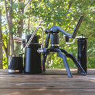 Outdoor photo showing the items in the Steam Travel Kit including the Flair 2GO, Royal Grinder, Wizard Steamer and Milk Pitcher.