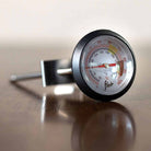Flair analog milk steaming thermometer on a counter.