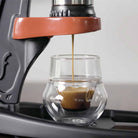 Close up view of an espresso extraction in a glass cup with crema.