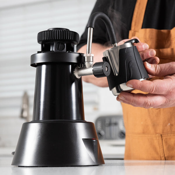 Flair eWizard Steamer on a counter steaming milk with the Flair Milk Pitcher.