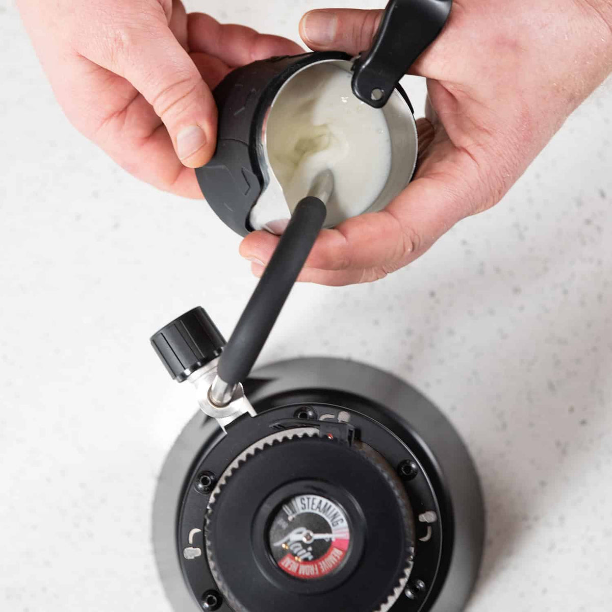 Top down view of the Flair eWizard electric milk steamer making steamed milk for latte art.