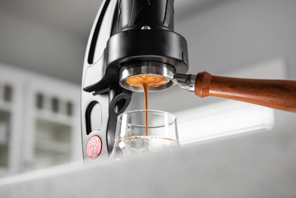 Espresso being poured from a coffee machine into a glass.