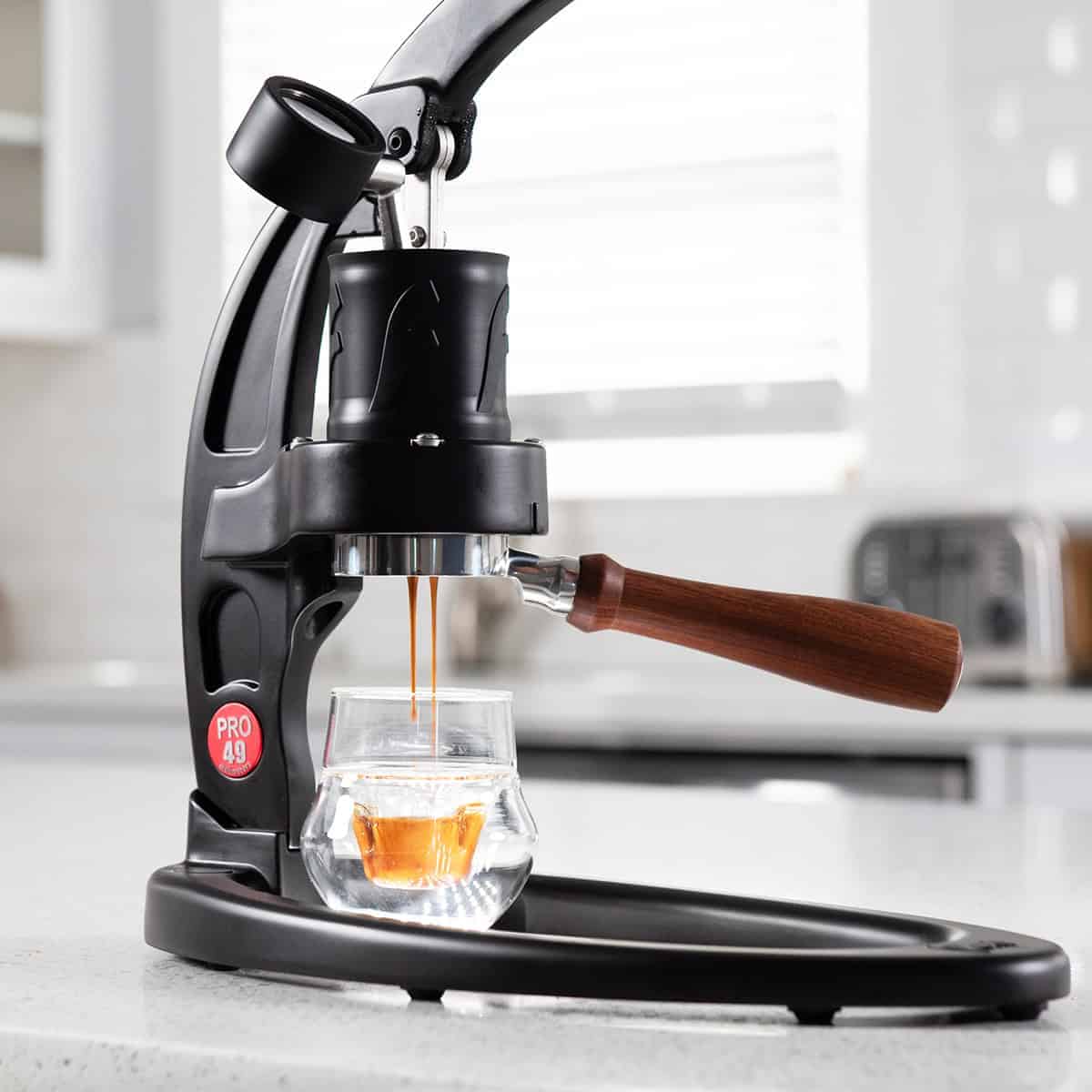Flair 49 PRO manual espresso maker with the lever raised and brewing espresso.