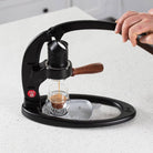The Flair 49 PRO manual lever espresso maker brewing espresso on a counter.