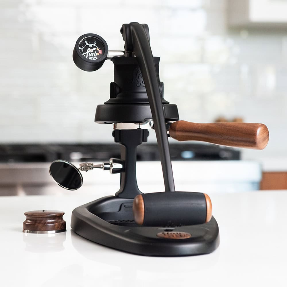Flair 58 Plus 2 manual espresso maker on a kitchen counter with a blurred background