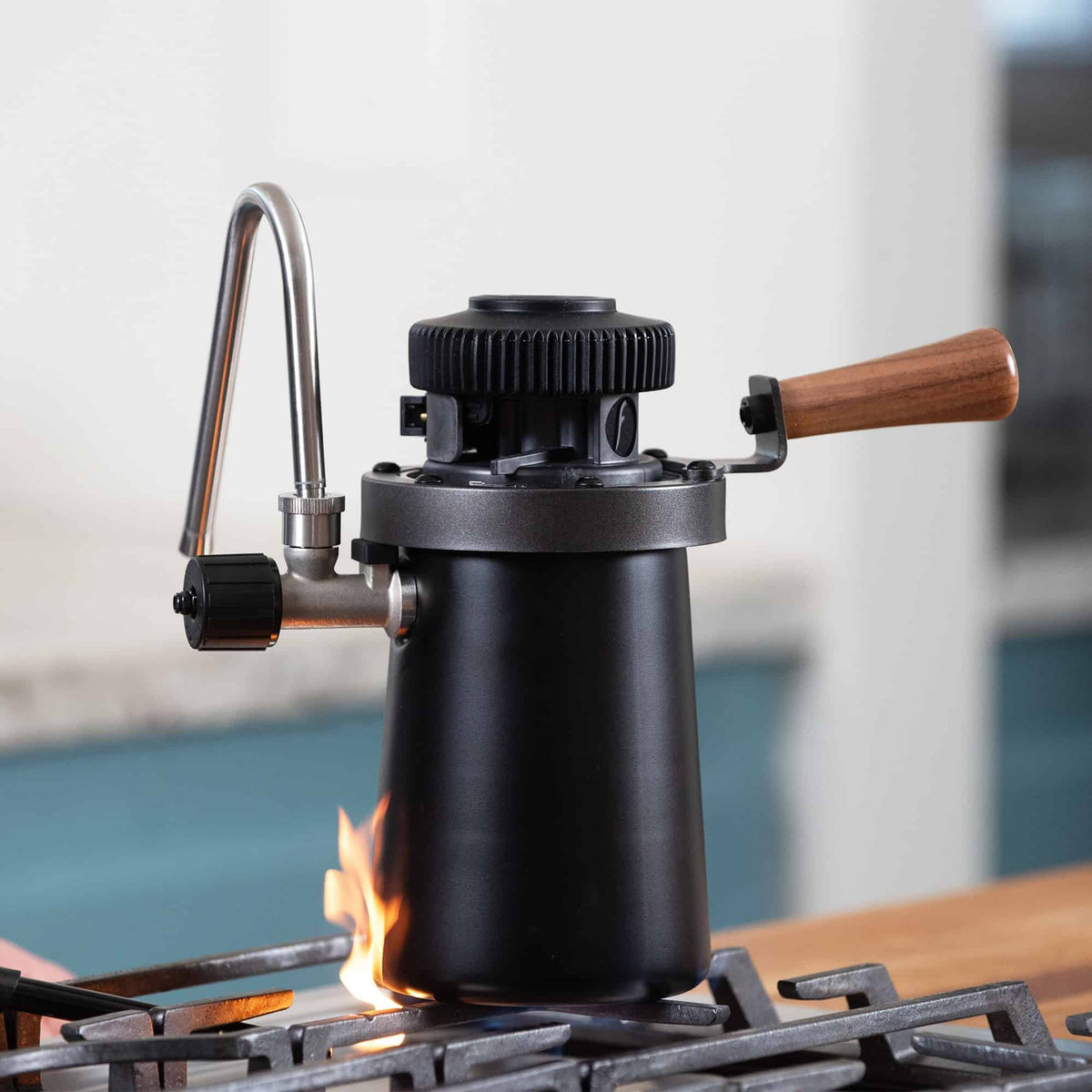 Flair Wizard Steamer on a gas stovetop with a flame.
