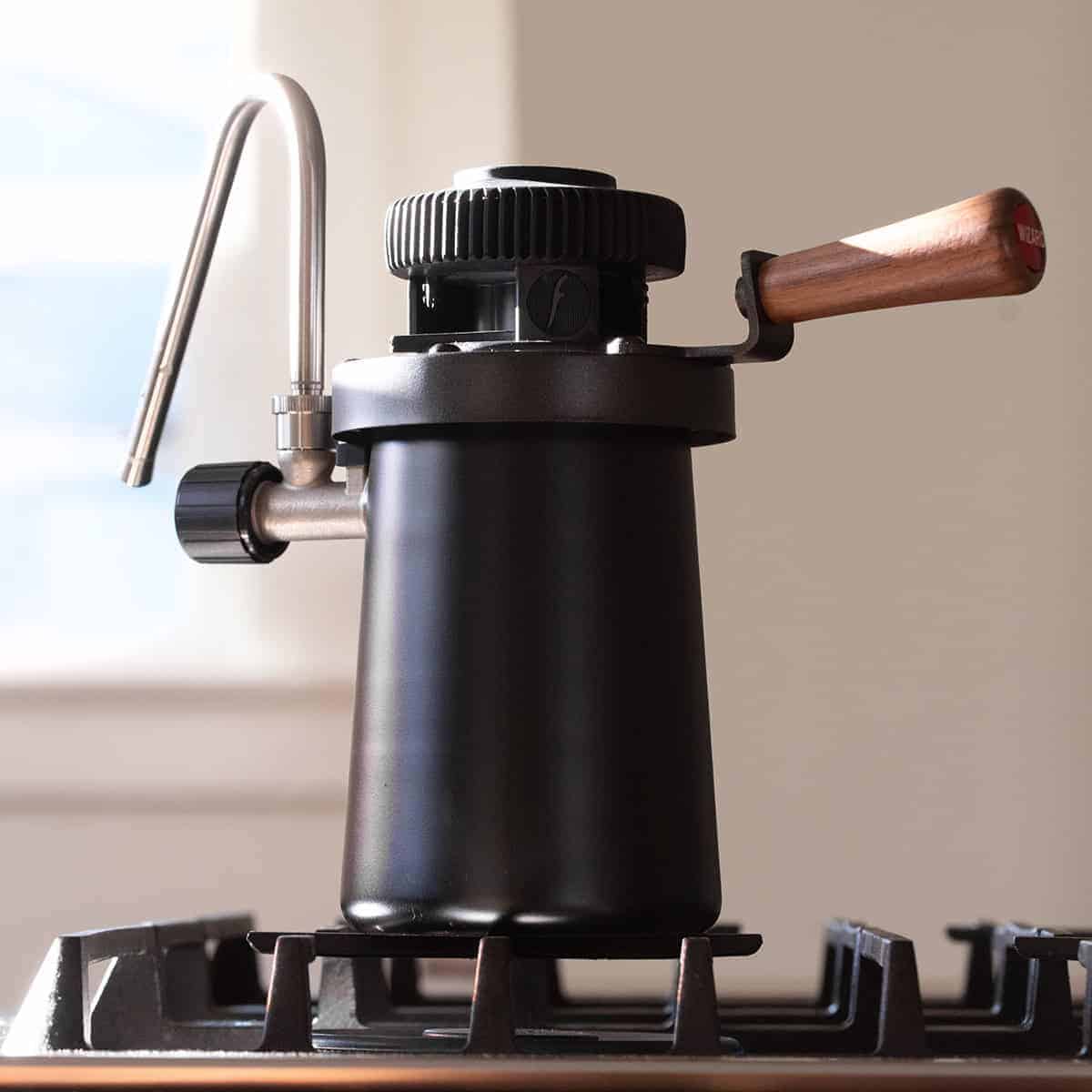 Flair Wizard stovetop milk steamer on a gas stove.